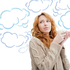 Portrait of beautiful red hair girl drinking coffee on winter background. Blank cloud balloon with her thoughts flying around her